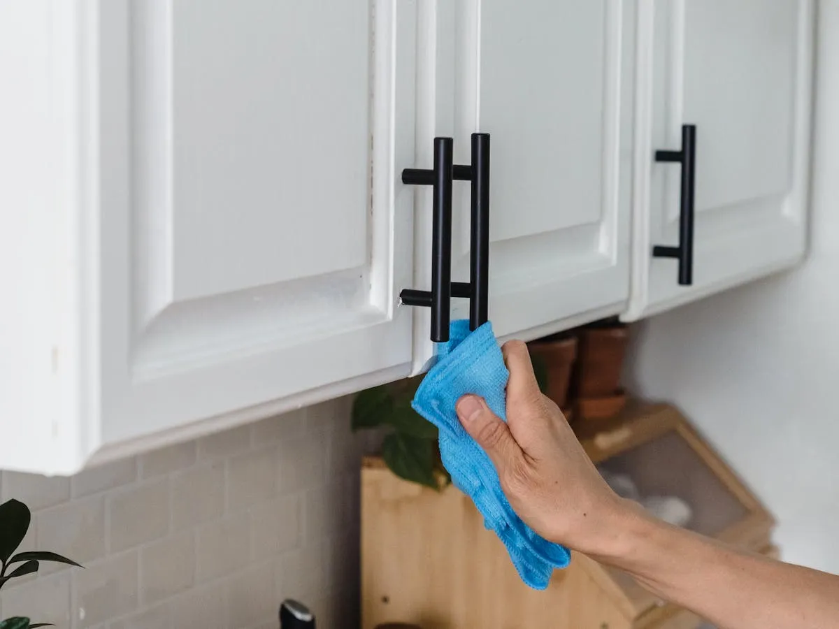 Wiping inside kitchen cabinets during a move-out clean