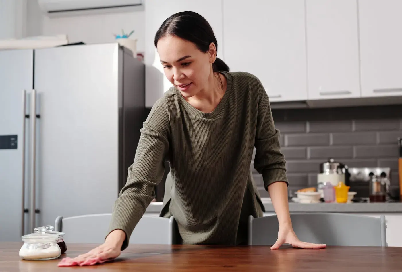 Wiping a kitchen table in a bright Calgary home