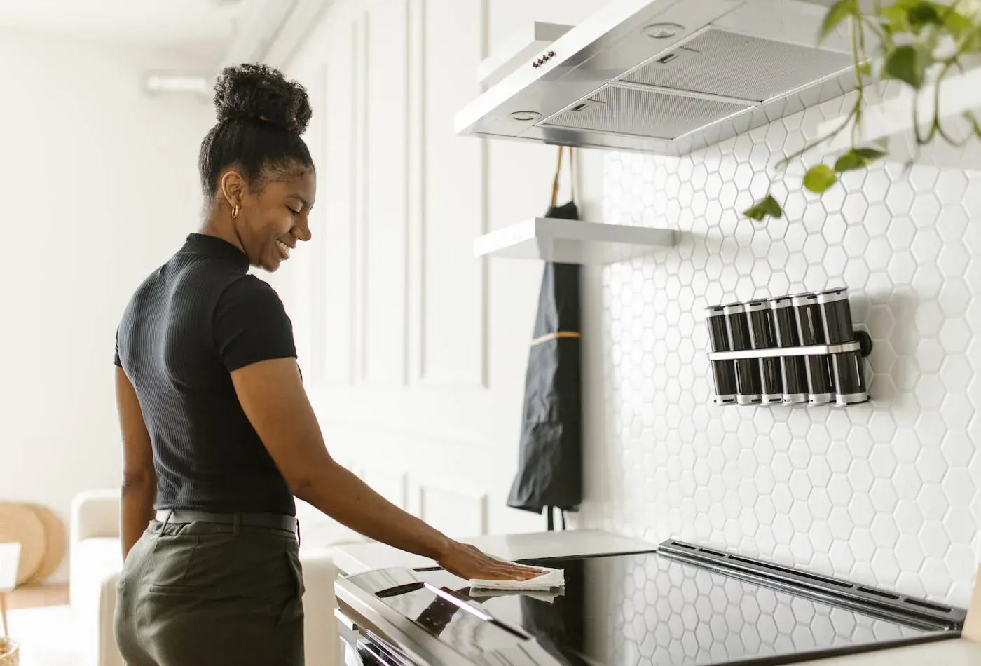 Wiping a stovetop in a bright, modern kitchen